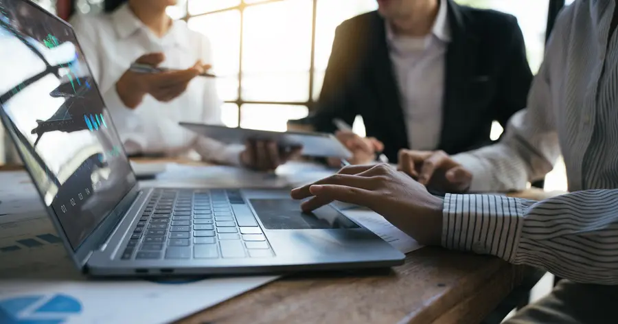 Team of business investment consultant analyzing company annual financial report working with documents pie and donut chart, using laptop, Business and Financial concept.