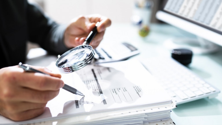 Audit And Fraud Investigation. Auditor Using Magnifying Glass